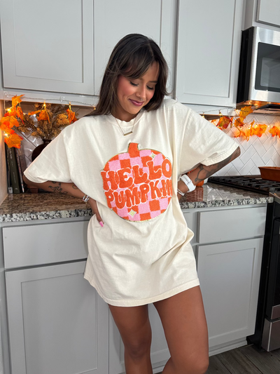 Woman wearing a 'Hello Pumpkin' shirt in a kitchen